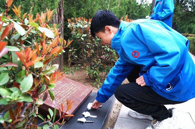 學(xué)生們向烈士紀(jì)念碑敬獻(xiàn)小白花.jpg